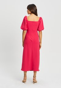 Abito midi rosa con maniche a sbuffo corte, scollatura quadrata e chiusura con cerniera sul retro. Tessuto morbido, aderente in vita, design fluido.