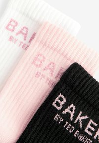 Tre paia di calzini a righe, in nero, rosa e bianco, ciascuno con il testo stampato "BAKER BY TED BAKER" in colori contrastanti.