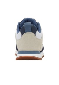 Vista posteriore di una sneaker beige, blu e bianca con un inserto in tessuto e suola in gomma marrone su uno sfondo bianco.