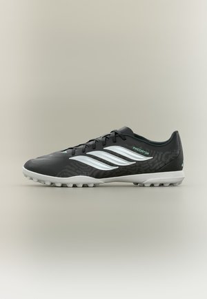 Chaussure de football Adidas Predator noire et blanche avec semelle texturée et laçage à l’avant, vue de profil sur fond neutre.