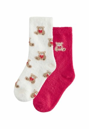 To sæt fuzzy sokker: et sæt hvidt med teddy bjørne mønster, det andet i ensfarvet pink. Blød, varm tekstur, velegnet til hyggeligt brug.