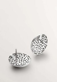 Pendientes redondos metálicos con un diseño perforado, con un acabado plateado brillante y un cierre de tipo post-back.