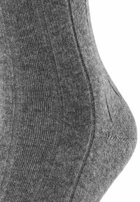 Graue gerippte Socke mit weichem Textil, sanfter Form und dezentem Muster an den Seiten. Keine sichtbaren Marken- oder Hardwaredetails.