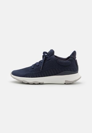 Baskets de sport en maille navy avec une tige texturée, bout rond, semelle intermédiaire blanche et un branding discret, dotées de lacets plats et d'un col rembourré.