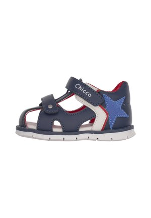 Mørkeblå lædersandal med stjerneaccent, rød inderside og hvide detaljer. Har velcrolukning og udskæringer for bedre luftcirkulation.