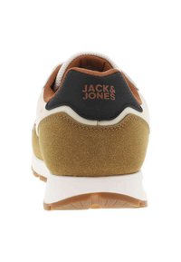 Zapatilla con parte superior de ante en tonos beige y marrón claro, lengüeta negra en el talón, mediopie blanca y suela de goma marrón. Presenta el logo "JACK & JONES" en el talón.