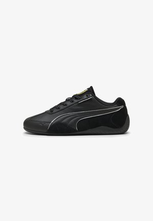 Scarpa sportiva nera caratterizzata da una combinazione di pelle liscia e suede, con un design elegante, lacci e una suola in gomma testurizzata.