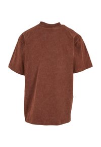 Brun oversized T-skjorte, kort erm, ensfarget, lett teksturert stoff, med klassisk rund halsdesign og en avslappet passform.