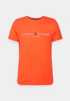 Orange cotton T-shirt with a crew neck, featuring "TOMMY HILFIGER EST. 1985" printed in white, and a small logo accent on the sleeve.
