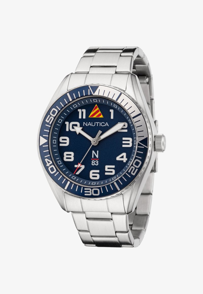 Nautica-horloge met een roestvrijstalen band, marineblauw dial, witte cijfers en zilveren accenten; heeft een hand met rode accenten en een logo.