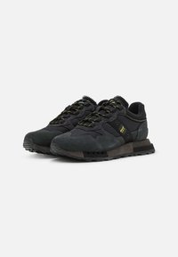 Scarpe sportive nere con tomaia in suede e tessuto, suola testurizzata, dettagli grigi e lacci gialli a contrasto. Design leggero per il massimo comfort.