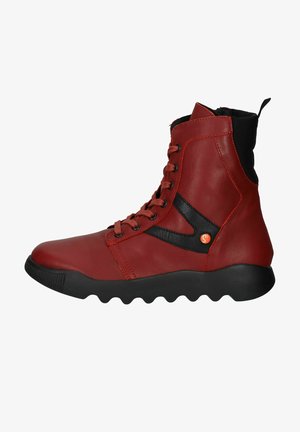 Red leather ankle boots with black textile accents, lace-up design, textured rubber sole, and distinctive wave pattern on the bottom.