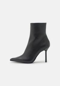 Bottine en cuir noir à bout pointu, talon aiguille fin, design sans couture et texture lisse. Pas de quincaillerie ni de motifs visibles.