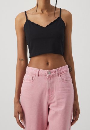 Schwarzes, kurzes Tanktop mit gewelltem Ausschnitt, kombiniert mit hellrosa High-Waist-Jeans; beide aus weichem, glattem Baumwollstoff gefertigt.