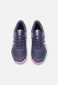 Lilla sportssko med mesh-overdel, hvide detaljer, polstret krave og pink sål. Snørebåndene er mørkelilla med forstærkede snørehuller.