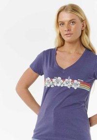 Paarse katoenen t-shirt met korte mouwen en een V-hals. Kenmerkt zich door een witte bloemenprint en horizontale strepen in rood en blauw.