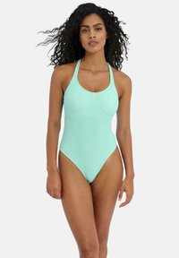 Maillot de bain une pièce vert menthe en tissu texturé, avec des jambes hautes et un col rond, doté de fines bretelles croisées dans le dos.