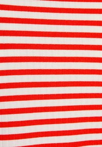 Röd och vit randig tygtextur med växelvis tjocka och tunna ränder, som visar ett ribbat mönster genom hela ytan.