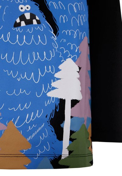 Tessuto blu con un personaggio blu in stile cartone animato con accenti bianchi, circondato da alberi di varie forme nei colori rosa, bianco, marrone e verde.