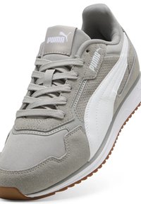 Gray athletic shoe made of suede and mesh with white accents. Features a padded tongue, round laces, and a textured rubber sole.