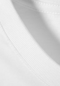 White cotton t-shirt collar with ribbed texture, smooth fabric, and clean stitching, showing a close-up of the neckline detail.