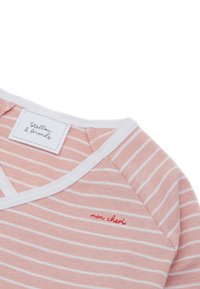 Top in cotone a righe rosa con bordi bianchi. Presenta un design a scollo a V e la scritta "mon chéri" ricamata in rosso vicino al colletto.