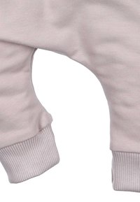 Lichtroze katoenen jumpsuitstof met geribbelde manchetten, met een gebogen pijpdesign voor comfort. Zachte textuur en flexibele pasvorm.