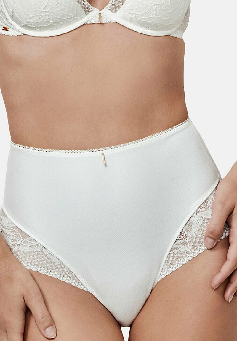 Culotte taille haute blanche en tissu lisse, avec des panneaux latéraux en dentelle et une fine bande décorative. Accent doré discret à la taille.