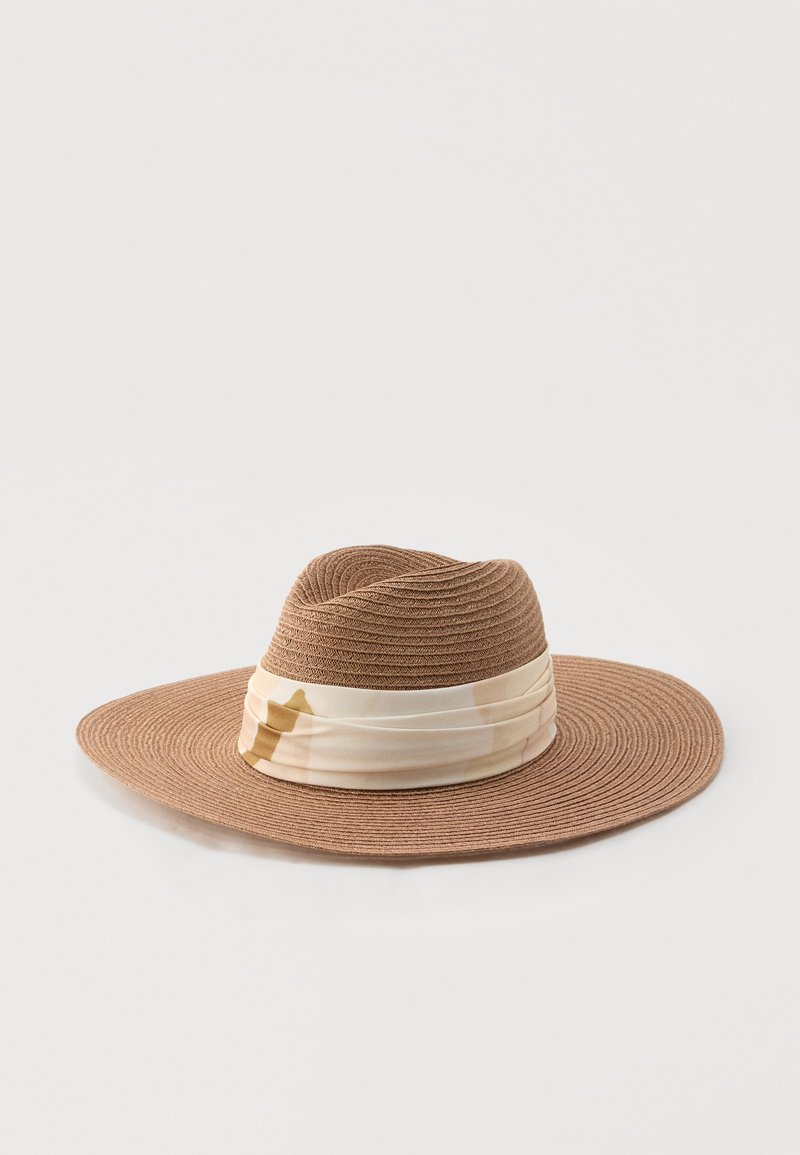 Καφέ πλεκτό καπέλο με φαρδύ γείσο και μπεζ και ανοιχτό καφέ υφασμάτινη ταινία με σχέδια γύρω από τη βάση της κορόνας.