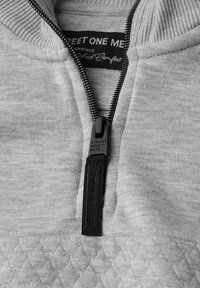 Pullover grigio con zip e colletto a coste, caratterizzato da un motivo a diamante testurizzato sull'orlo e un tirante della zip con logo per un facile accesso.