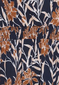 Tessuto blu navy con grandi motivi floreali marroni e dettagli bianchi. Il materiale è morbido e il design include una vita elasticizzata arricciata.