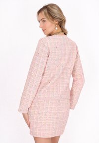 Rosa Tweed-Jacke mit langen Ärmeln und taillierter Silhouette. Strukturiertes Gewebe mit mehrfarbigen Fäden und minimalistischem Design.