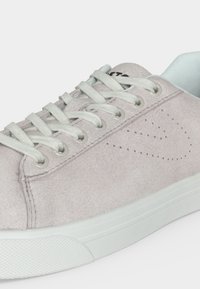 Ανοιχτό γκρι σουέτ αθλητικό παπούτσι με λευκά κορδόνια, διάτρητο πλευρικό σχέδιο και λευκή λαστιχένια σόλα σε μονόχρωμο φόντο.