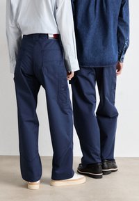 Marine cargobroek met meerdere zakken, gemaakt van stevig materiaal. Gecombineerd met casual schoeisel, met een nette en ontspannen pasvorm.