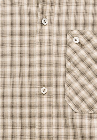 Chemise à carreaux beige et marron, devant avec trois boutons blancs et une poche poitrine assortie boutonnée sur le côté droit.