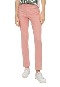 Jeans skinny rosas hechos de una mezcla de algodón, con cierre frontal de botón y diseño de cinco bolsillos, combinados con zapatillas blancas.