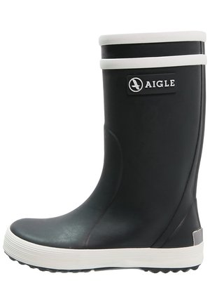 Bota de lluvia de goma negra con ribete y suela blanca, que cuenta con una puntera redonda y un parche con el logo de Aigle en el lateral.