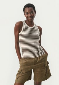 Gestreiftes, geripptes Tanktop in Braun und Creme, kombiniert mit olivgrünen Cargo-Shorts mit seitlichen Taschen und einer lässigen Passform.