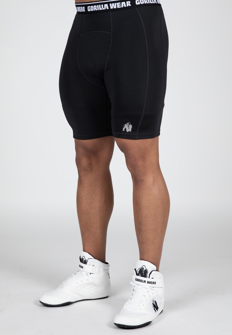 Zwarte sportieve shorts van rekbaar materiaal met een nauwsluitend ontwerp, met een wit "GORILLA WEAR" logo op de tailleband en een klein logo op het been.