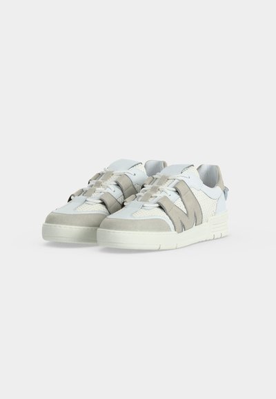 Ζευγάρι λευκά και ανοιχτογκρι casual sneakers με υφασμάτινες και λείες επιφάνειες και χοντρές λαστιχένιες σόλες σε μονόχρωμο φόντο.