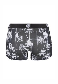 Black boxer shorts featuring a white palm tree and graphic print, with a black elastic waistband and logo detail.