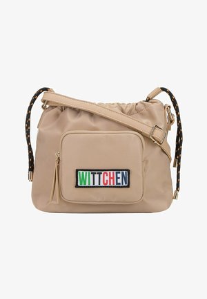 Bolso de hombro de tela caqui con parte superior de cordón, que cuenta con un bolsillo frontal y un parche colorido de "WITTCHEN". Detalles de tirantes en negro y naranja.
