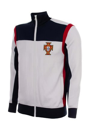 Wit trainingsjack met rits, marineblauwe en rode strepen, Portugese voetbalbadge op de linkerkant van de borst, zwarte kraag en manchetten, geen persoon zichtbaar.