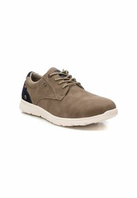 Zapato de ante beige con cordones, punta redonda, acento en el talón en contraste navy y suela de goma texturizada. Presenta sutiles detalles de costura.
