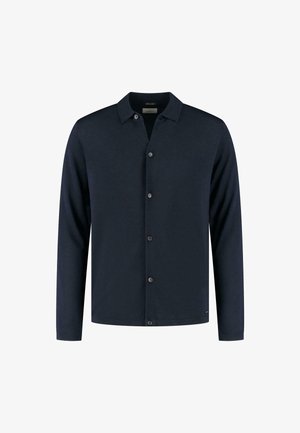 Camicia a maniche lunghe blu navy in un tessuto morbido, con colletto, chiusura a cinque bottoni e orlo dritto.