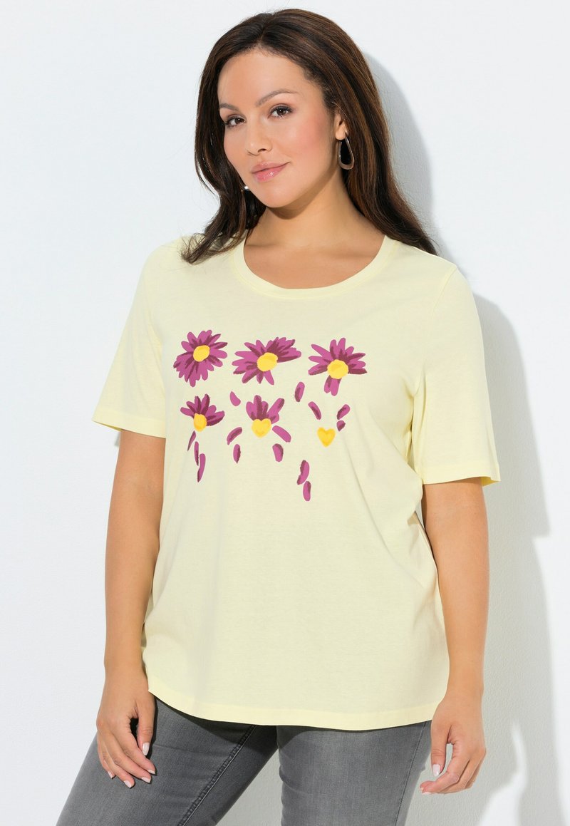 Camiseta amarilla de manga corta con escote redondo, con un diseño floral en tonos morados y amarillos, hecha de material suave de algodón.