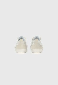 Γκρι αθλητικά παπούτσια από καστόρι και δέρμα με ομαλή υφή, χαμηλό προφίλ και αντίθετες ανοιχτές πινελιές στα πλαϊνά. Λευκές σόλες από καουτσούκ.