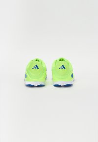 Jasne zelené športové topánky s modrými akcentmi. Textúrovaný sieťovaný zvršok a polstrovaná podrážka, s logom Adidas na zadnej strane.