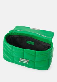Green quilted leather bag with a silver hardware accent and a zip closure. The interior is black fabric, offering a sleek and refined design.