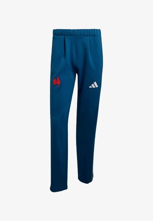 Blauwe sportbroek van zachte stof, met een rood haanlogo op de linker dij en een witte Adidas-logo op de rechter dij.